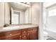 Well-lit bathroom featuring a large mirror, wood vanity and a shower over tub combination at 3225 Rinn Valley Dr, Longmont, CO 80504