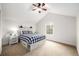 Well-lit bedroom with vaulted ceiling, a charming white-washed bed frame, and ample natural light from a window at 3225 Rinn Valley Dr, Longmont, CO 80504
