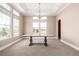 Bright dining room boasts large windows, coffered ceilings, and an elegant chandelier at 3225 Rinn Valley Dr, Longmont, CO 80504