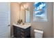 Powder bathroom with a white single sink vanity, modern faucet, and a window providing natural light at 7897 S Jamestown Ct, Aurora, CO 80016