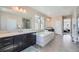 Luxurious bathroom featuring double sink vanities, a soaking tub, and a glass-enclosed shower at 7897 S Jamestown Ct, Aurora, CO 80016