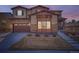 Charming home exterior featuring stone accents, a two-car garage, and a welcoming front porch under a dusky sky at 7897 S Jamestown Ct, Aurora, CO 80016