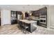 Modern kitchen featuring dark cabinetry, stainless steel appliances, and an island with bar seating at 7897 S Jamestown Ct, Aurora, CO 80016