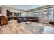 Open-concept living room with a large brown leather sofa and hardwood floors flowing into the kitchen at 7897 S Jamestown Ct, Aurora, CO 80016