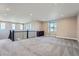 Open loft area with neutral carpeting, natural lighting, and a decorative railing at 7897 S Jamestown Ct, Aurora, CO 80016