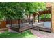 Multi-tiered deck with artificial grass and brick path leading to a covered patio area at 424 Arbor Dr, Lafayette, CO 80026