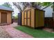 Backyard shed with adjacent small patio area on artificial turf and brick path at 424 Arbor Dr, Lafayette, CO 80026