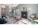 Open-concept living room featuring a fireplace, modern lighting, and an adjacent dining area at 360 S Estes St # C, Lakewood, CO 80228