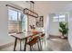 Bright dining room with a wooden table, modern light fixture, and large window at 3439 N High St, Denver, CO 80205