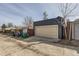 View of a modern garage, adjacent to trash receptacles and a brick wall at 3439 N High St, Denver, CO 80205