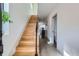 Bright hallway with wooden stairs, white walls, and a view into the open kitchen and bathroom at 3439 N High St, Denver, CO 80205