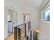 Modern hallway with hardwood floors and black railings, leading to the laundry room with a washer at 3439 N High St, Denver, CO 80205