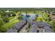 Aerial view of community featuring golf course, pond, townhomes, green landscaping, and parking at 2945 W Riverwalk Cir # B, Littleton, CO 80123