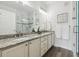 Bathroom with a double sink vanity, granite countertops, and a glass-enclosed shower at 2945 W Riverwalk Cir # B, Littleton, CO 80123