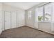 Bright bedroom with neutral walls, carpet, and large windows providing natural light and two double door closets at 2945 W Riverwalk Cir # B, Littleton, CO 80123