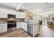 Open kitchen with white cabinets, stainless steel appliances, and view to the living area at 2945 W Riverwalk Cir # B, Littleton, CO 80123