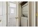 Convenient laundry closet with stacked washer and dryer units next to a door to the bedroom at 2945 W Riverwalk Cir # B, Littleton, CO 80123