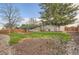 Large backyard featuring a well-kept lawn, mature trees, wooden fence, and a small deck at 367 Jupiter Dr, Lone Tree, CO 80124