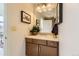 A bathroom with a single vanity, framed mirror and hanging towel in a well-lit space at 8165 E Lowry Blvd # 310, Denver, CO 80230