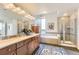 Elegant bathroom featuring a double vanity, a large mirror, soaking tub, and separate glass shower at 8165 E Lowry Blvd # 310, Denver, CO 80230