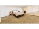 Spacious bedroom with carpet flooring, white walls, side tables, and a doorway leading to the bathroom at 8165 E Lowry Blvd # 310, Denver, CO 80230