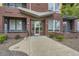 Modern brick building entrance with concrete walkway, partial awning, and well-maintained landscaping at 8165 E Lowry Blvd # 310, Denver, CO 80230