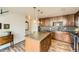 Well-equipped kitchen with island, dark wood cabinets and tile backsplash at 8165 E Lowry Blvd # 310, Denver, CO 80230