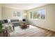 Bright living room featuring a modern sectional sofa, a stylish coffee table, and large windows at 740 Lotus Way, Broomfield, CO 80020