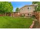 Large, landscaped backyard featuring green grass, patio, and trees at 6798 Depew St, Arvada, CO 80003