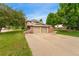 Charming two-story home with a brick facade, attached two-car garage, and a lush green lawn at 6798 Depew St, Arvada, CO 80003