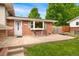 Inviting front porch of a brick home with seating, a well-maintained lawn, and a bright, welcoming entrance at 6798 Depew St, Arvada, CO 80003