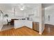 Bright and efficient kitchen featuring white cabinets, stainless steel appliances, and hardwood floors, open to the dining area at 6798 Depew St, Arvada, CO 80003