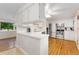 Well-lit kitchen featuring white cabinetry, stainless steel appliances, and hardwood floors for a modern, clean look at 6798 Depew St, Arvada, CO 80003