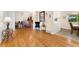 Spacious living room with gleaming hardwood floors, neutral paint, and an open layout to the dining area and staircase at 6798 Depew St, Arvada, CO 80003