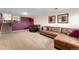 Spacious living room with carpet flooring, a leather sofa, and artwork on the wall at 6798 Depew St, Arvada, CO 80003
