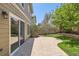 Patio and backyard with a stone patio, lush lawn, and mature trees perfect for outdoor enjoyment at 7838 W Layton Way, Littleton, CO 80123