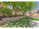 Lush backyard with a tiered retaining wall, privacy fence, and mature trees providing shade and serenity at 7838 W Layton Way, Littleton, CO 80123