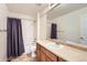 Bathroom featuring a vanity with a sink, toilet, bathtub, shower with a curtain, and beige tiled floor at 7838 W Layton Way, Littleton, CO 80123