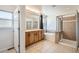 Primary bathroom featuring double vanities, soaking tub, glass shower, and a window for natural light at 7838 W Layton Way, Littleton, CO 80123