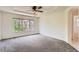 A bright, empty bedroom with large windows and neutral carpet features a tray ceiling and ceiling fan at 7838 W Layton Way, Littleton, CO 80123