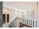 Open foyer with wrought iron railing, showcasing abundant natural light and hardwood floors at 7838 W Layton Way, Littleton, CO 80123
