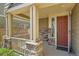 Inviting front porch showcasing stone columns, wood railing, and a stylish front door at 7838 W Layton Way, Littleton, CO 80123