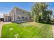Expansive backyard with lush green lawn, a patio, and a charming weeping willow tree at 15901 E 106Th Way, Commerce City, CO 80022