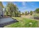 Picturesque backyard featuring a well-manicured lawn, wooden fence, mature tree, and a cozy patio area at 15901 E 106Th Way, Commerce City, CO 80022
