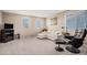 Bright living room with a white leather sectional couch and large windows with natural light at 15901 E 106Th Way, Commerce City, CO 80022