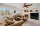 Comfortable living room with a fireplace, large windows, and a ceiling fan at 15901 E 106Th Way, Commerce City, CO 80022