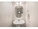 Well-lit powder room features a pedestal sink and a decorative mirror at 15901 E 106Th Way, Commerce City, CO 80022