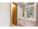 Bathroom featuring a vanity with an expansive mirror and wood frame door at 23 Carla Way, Broomfield, CO 80020