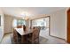 Elegant dining room with a wooden table set for eight, flowing into an adjacent living room at 23 Carla Way, Broomfield, CO 80020