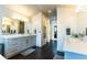 Elegant bathroom featuring dual vanities, dark wood floors, and a walk-in closet entrance at 1152 S Ogden St, Denver, CO 80210